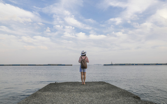 背着背包在海边欣赏风景的女人