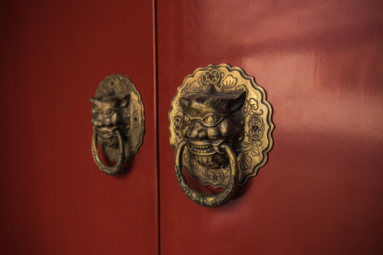中式红色木门上的兽头叩门环和铜