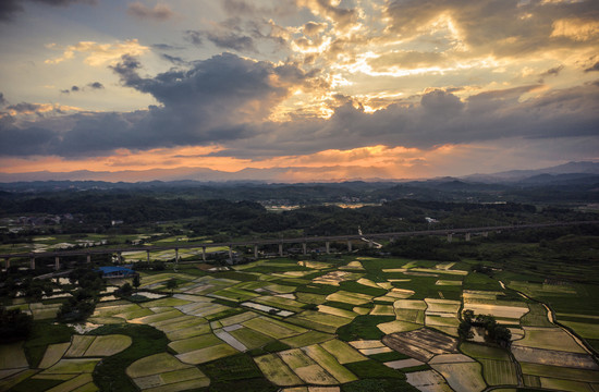 夕阳晚霞中群山间的田园风光