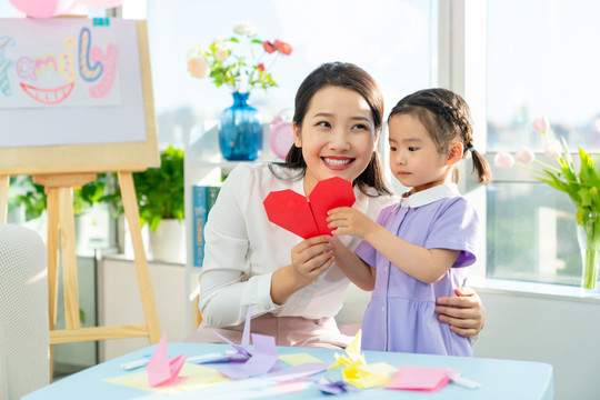 老师和小女孩一起折纸