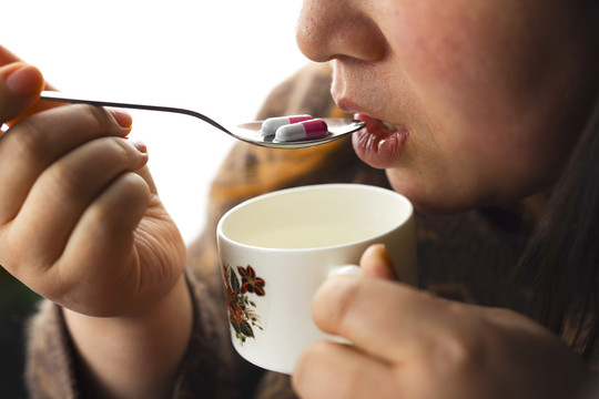 女人端起水杯吃药