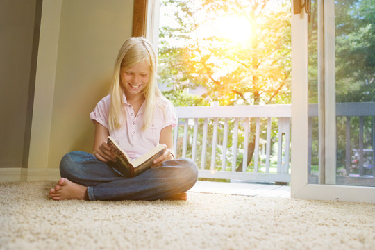 坐在地毯上看书的女孩