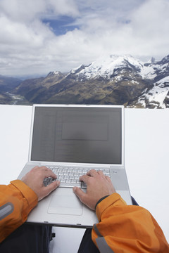 雪山背景下使用电脑的人