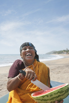 在海滩切西瓜的印度女性