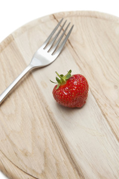有草莓和叉子的短切木盘