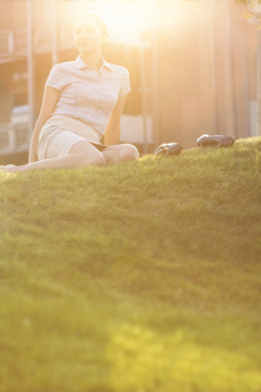 草坪上放松的年轻女商人