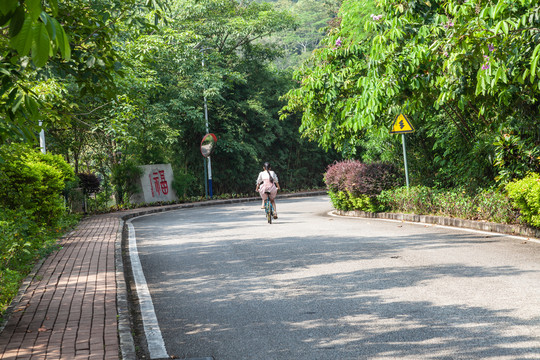 一个长辫子姑娘在公园骑山地车