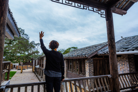 古村楼台上招手的女人