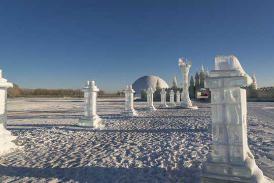 夕阳下雪原上晶莹剔透的冰雕建筑