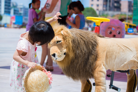 与狮子玩偶一起的小女孩