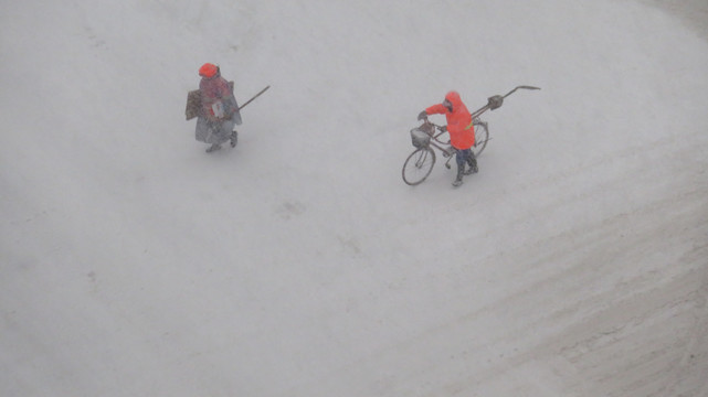 俯拍大雪中行走的環(huán)衛(wèi)工人