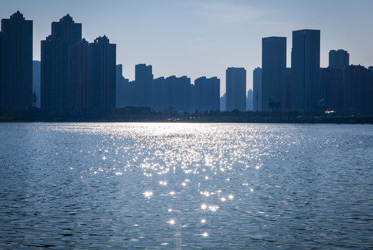 城市傍晚蓝色湖面波光阳光背景
