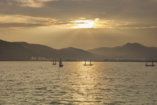 日落帆船山脉湖泊与水面光影