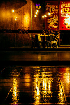 黎明雨后地面反射的饭馆灯光
