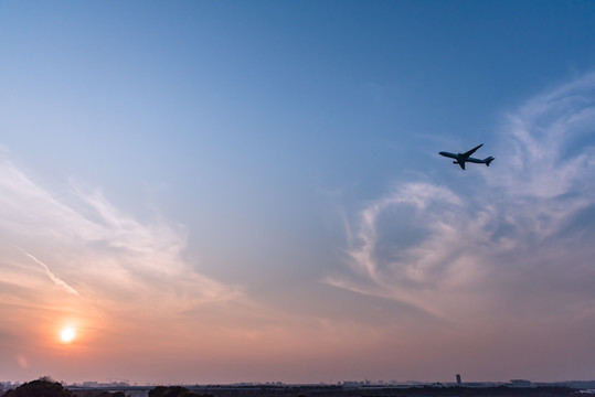 日落下在空中飞行的客机飞机