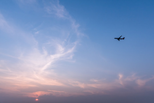 日落下在空中飞行的客机飞机