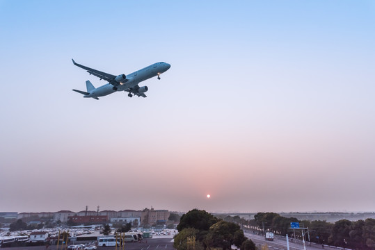 日落下在空中飞行的客机飞机