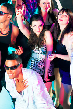 在迪斯科俱乐部跳舞-一群人，不同种族的男人和女人，随着音乐跳舞有很多乐趣
