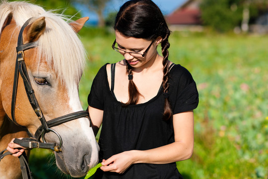 牧场里牵着马的女孩