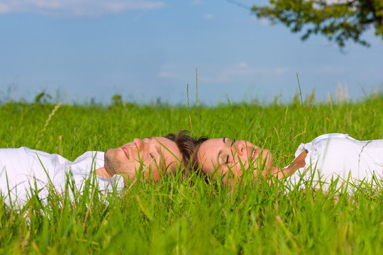 夏日躺在草地上的幸福夫妻