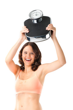 饮食和体重-年轻女子用体重秤，她对成功感到高兴
