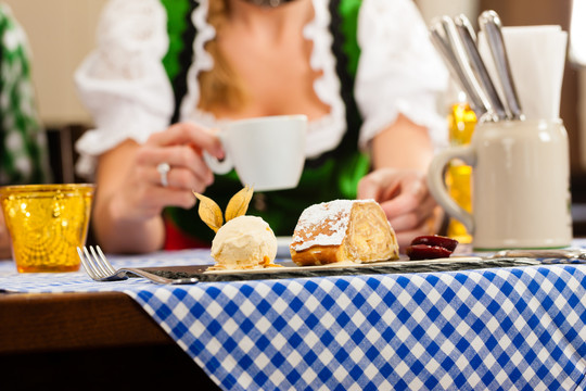 年轻女子在传统的巴伐利亚餐厅或酒吧吃甜点，特写镜头