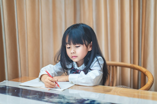 坐在书桌前写作业的小女孩