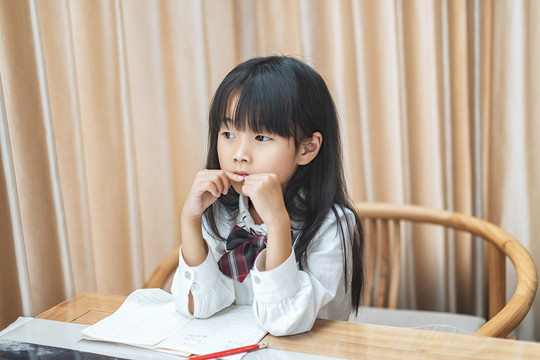 坐在书桌前写作业的小女孩