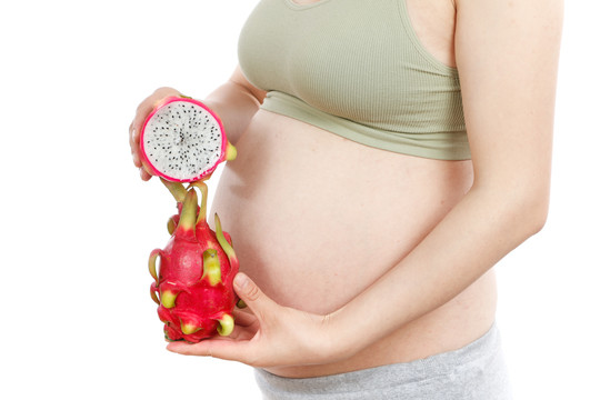 孕妇手上拿着新鲜火龙果
