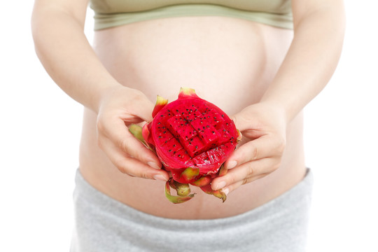 孕妇手上拿着半边红心火龙果
