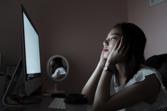 亚洲年轻的泰国女人厌倦了在电脑前加班。有健康问题偏头痛，失眠，头痛。