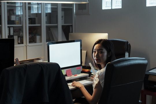 悲伤和紧张的亚裔女性在办公室晚上用电脑工作-加班概念。