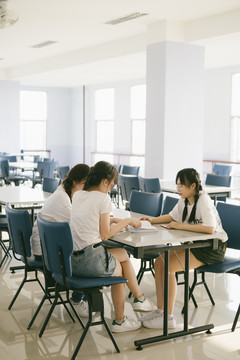 三个漂亮的亚泰学生在学校内的女宿舍开会。一起做作业。