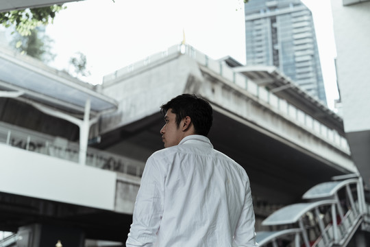 背景图-曼谷天空火车站台上穿着白色正式衬衫的成熟亚洲商人。