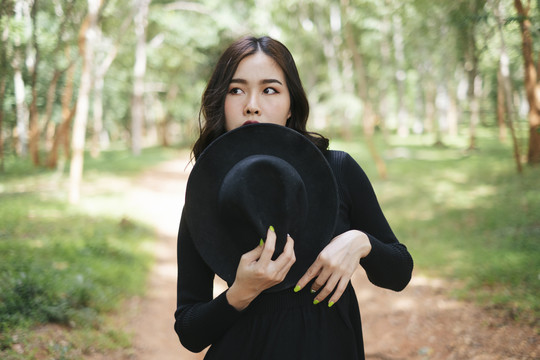 黑巫师女孩用帽子遮住半张脸。