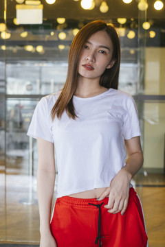 时尚写真-美丽的亚洲年轻女子在白色衬衫和红色运动裤在美丽的黄色背景摆姿势。