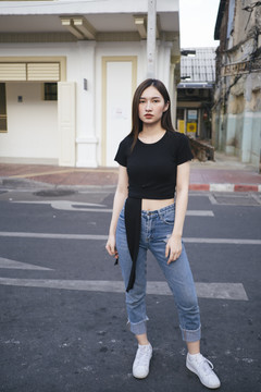 全长时尚肖像-美丽的时髦的亚洲年轻女子在黑色衬衫和牛仔裤裤子站在路上。