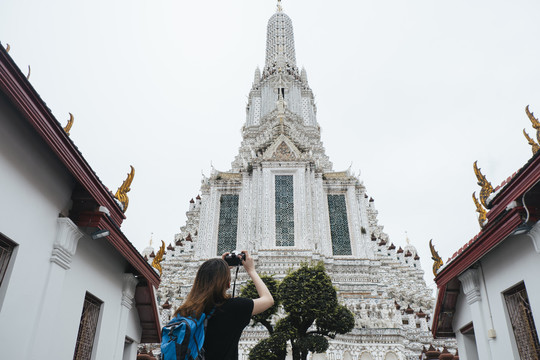 亚洲背包客在wat arun用相机拍照。