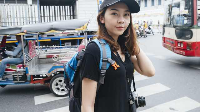 美丽的亚洲背包客在曼谷过马路。