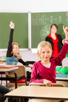 教育-年轻的女教师和学生在他的形式的小学或小学教学