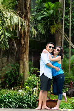 印尼夫妇在热带环境中，他拥抱妻子
