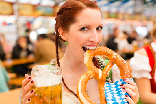 穿着传统巴伐利亚服装的年轻女子，在啤酒帐篷里参加节日或啤酒节