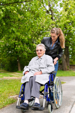 这位年轻女子坐着轮椅在养老院看望她的祖母