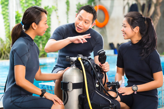 亚洲人在潜水学校的潜水员课程中穿着带氧气罐的潜水服