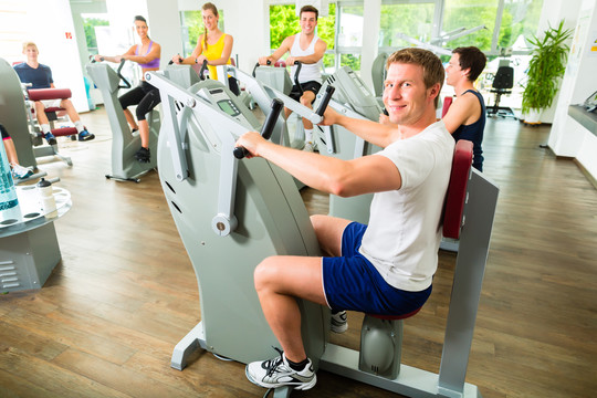 一群男女在健身俱乐部或健身房的机器上训练