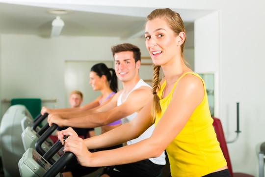 一群男女在健身俱乐部或健身房的机器上训练