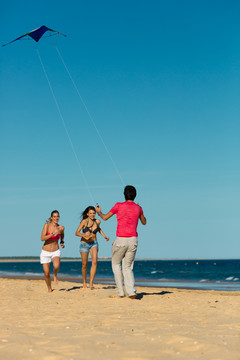 沙滩上放风筝的年轻人