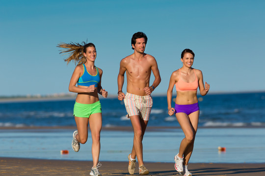 一群男女运动爱好者在沙滩上慢跑