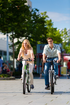 情侣-男人和女人-骑自行车或自行车在他们的空闲时间和乐趣在一个阳光明媚的夏日