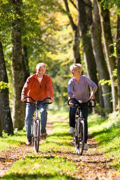 老年男女在户外骑自行车锻炼，他们是一对